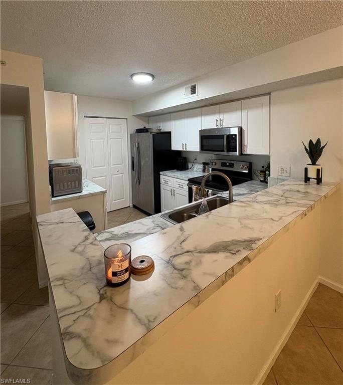 a kitchen with stainless steel appliances kitchen island granite countertop a sink and cabinets