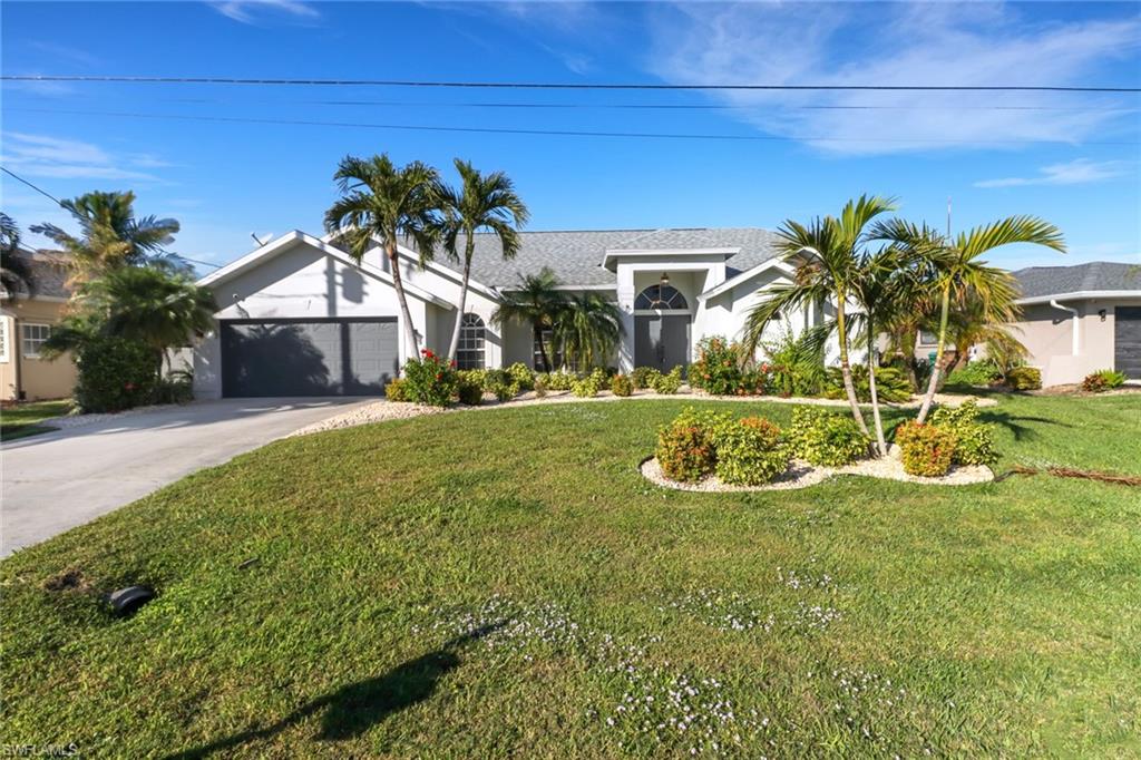 View of front of house featuring a front lawn and a garage