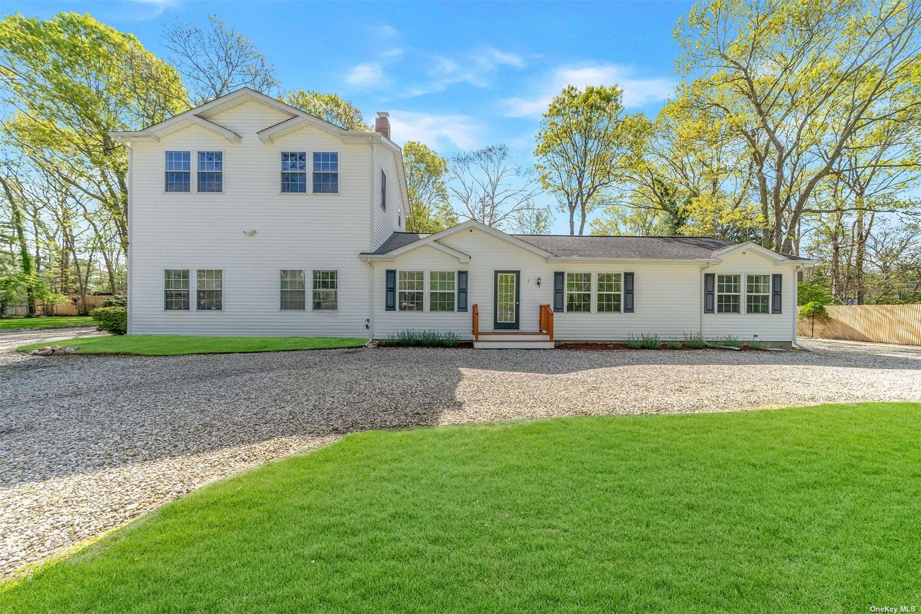 a front view of a house with a yard and trees