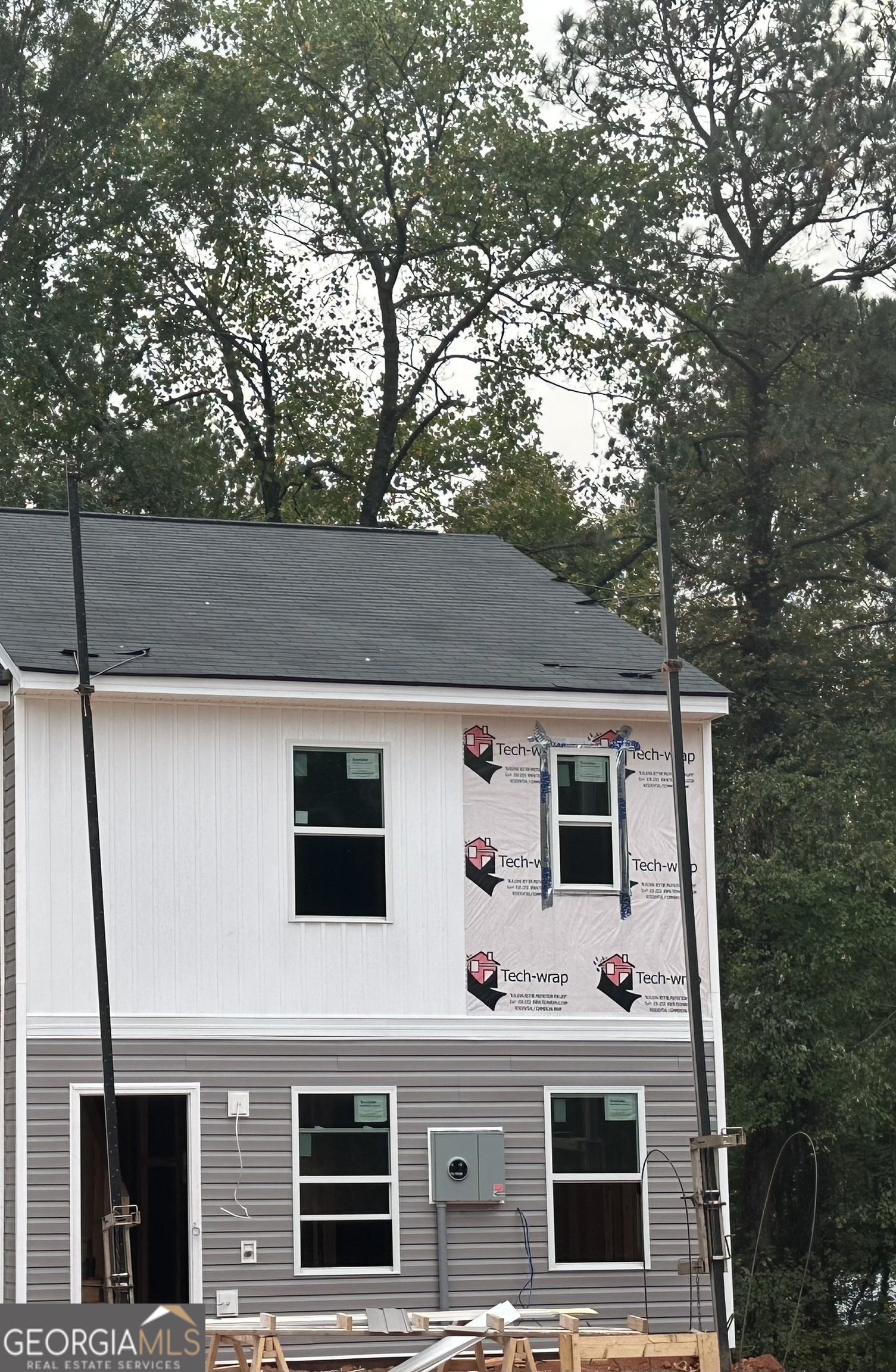 a front view of a house with a tree