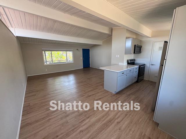 a view of a kitchen with window and wooden floor