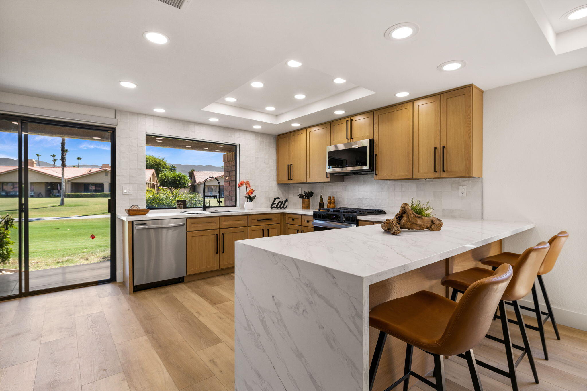 a kitchen with a sink a counter top space stainless steel appliances and cabinets