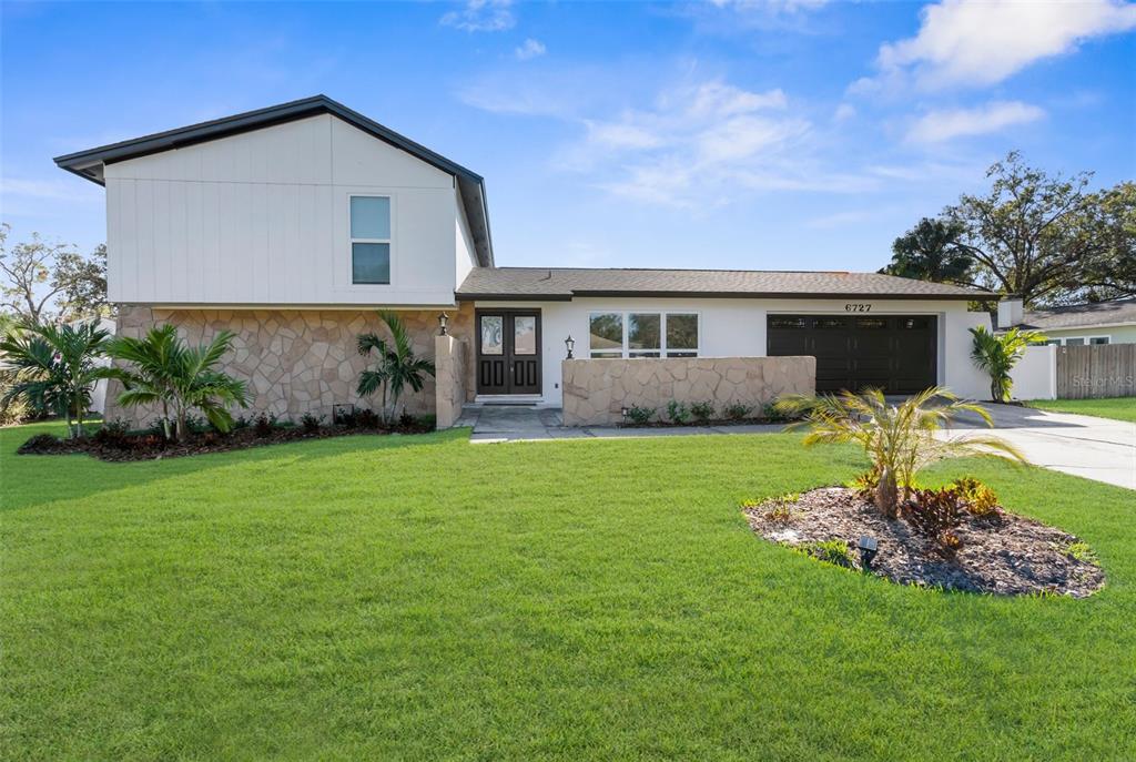 a front view of house with yard and green space