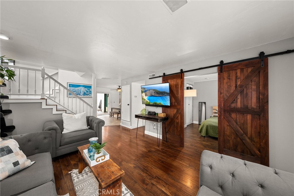 a living room with furniture a flat screen tv and a window