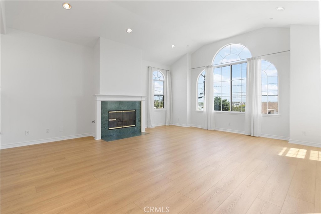 an empty room with windows and fireplace