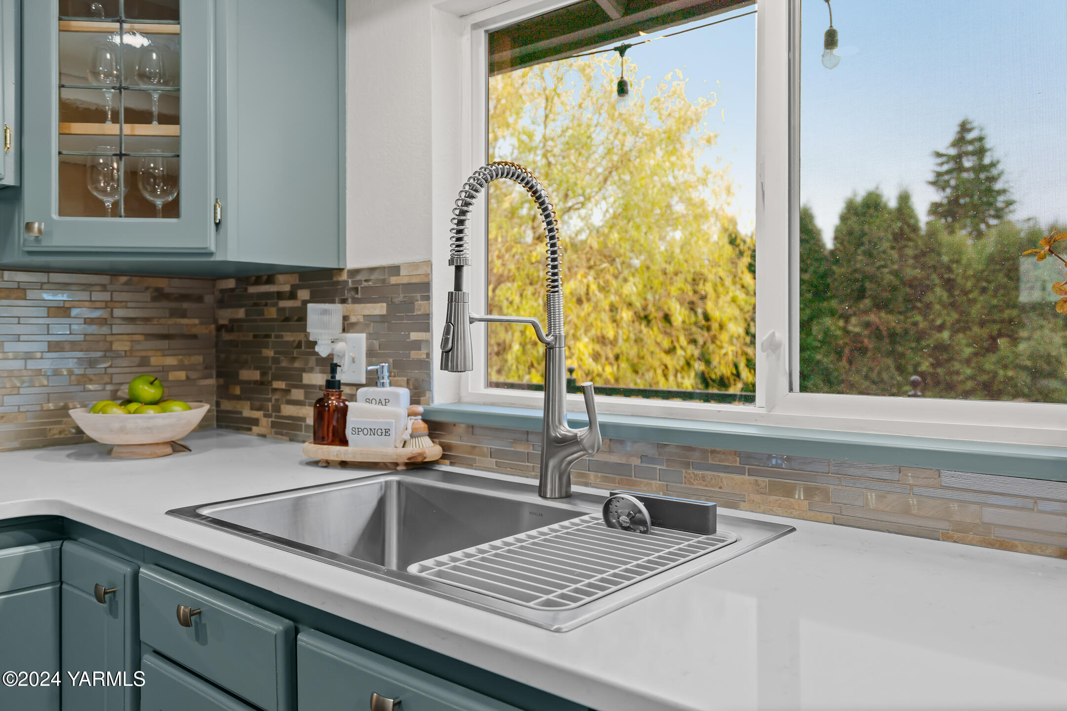 a kitchen with sink a window and wooden floor