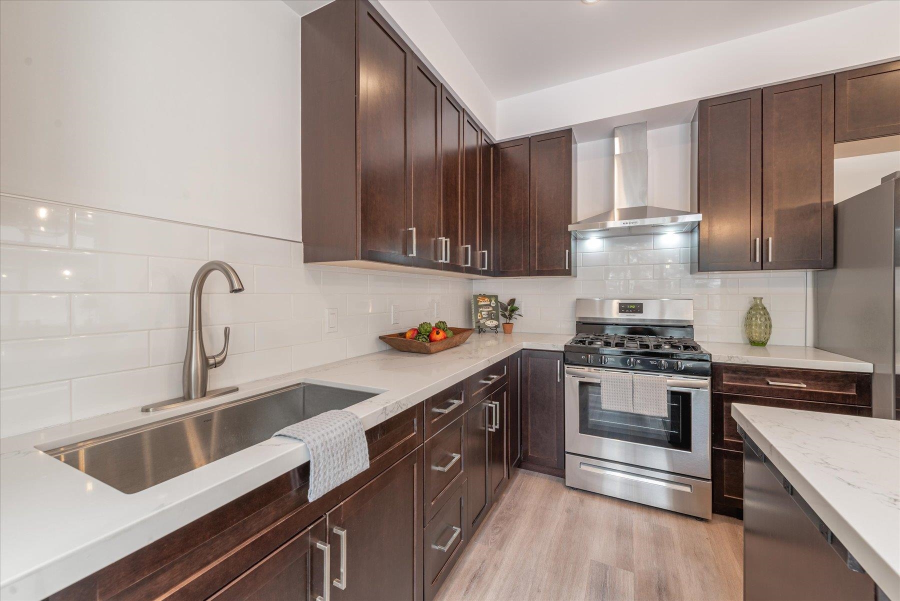 a kitchen with granite countertop a sink stove and cabinets