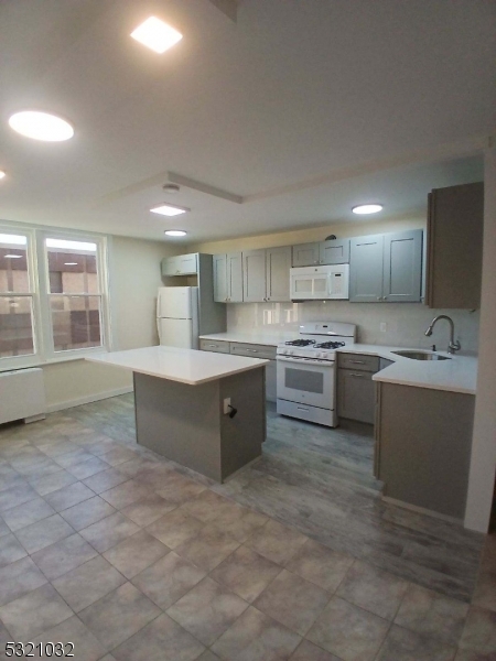 a large kitchen with a sink and cabinets