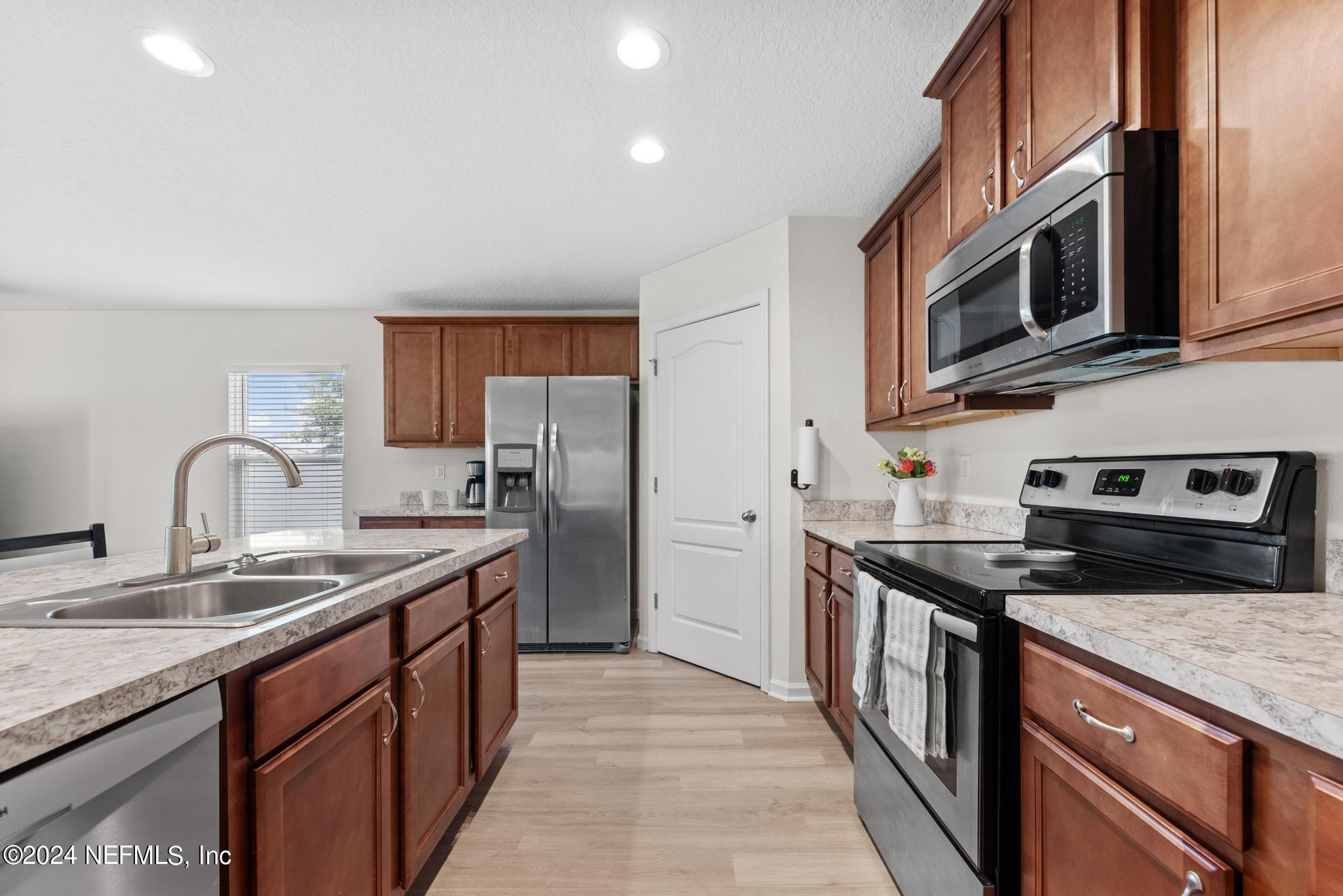 a kitchen with stainless steel appliances granite countertop a sink stove microwave and refrigerator