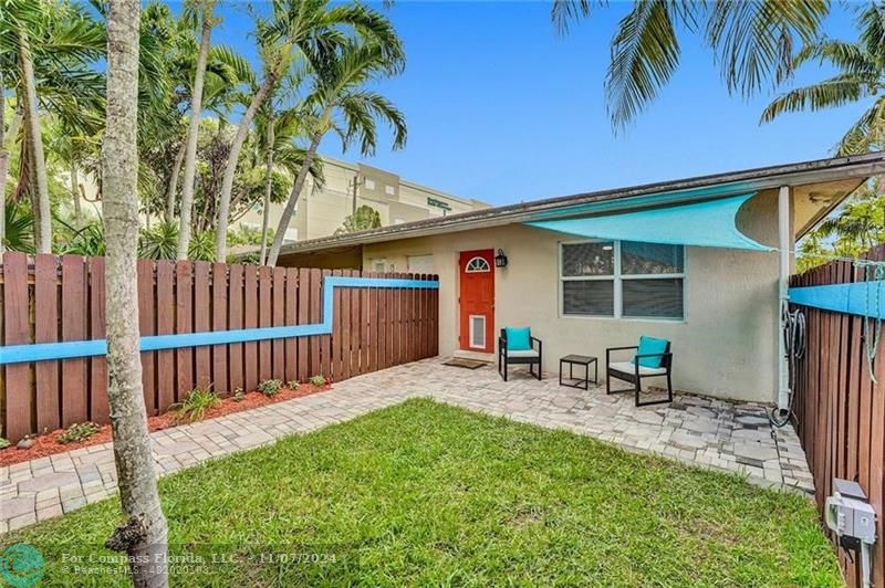 a view of a backyard with a sitting area and wooden fence