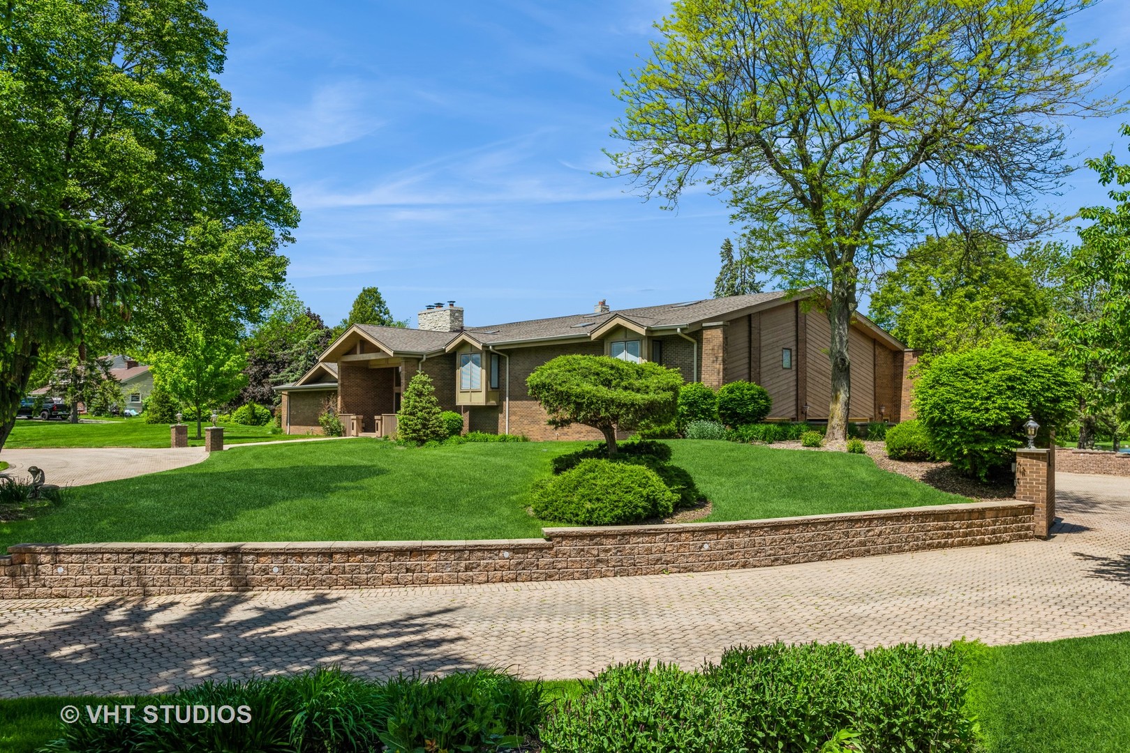 a front view of a house with a yard and potted plants