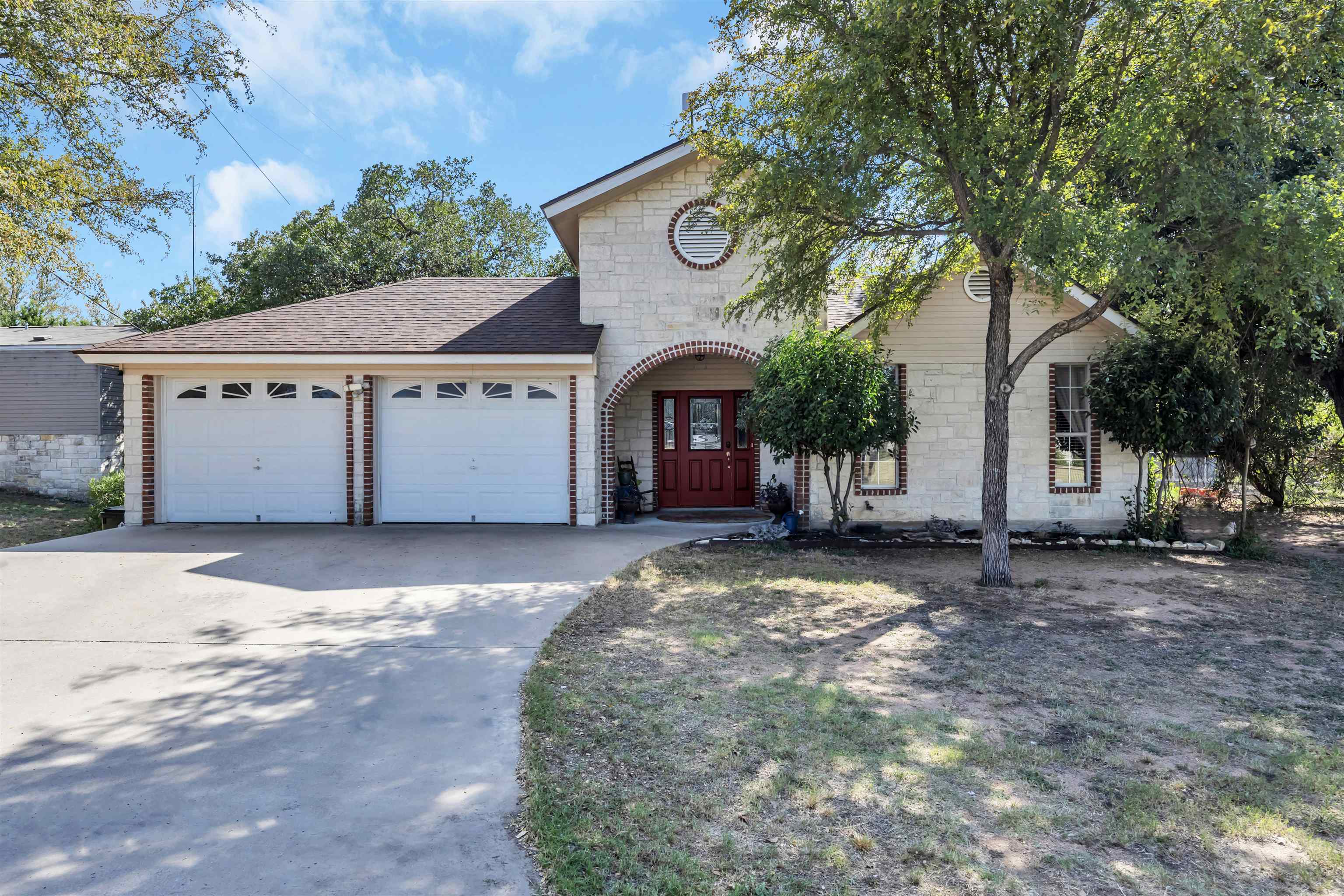 a front view of a house with a tree and garage