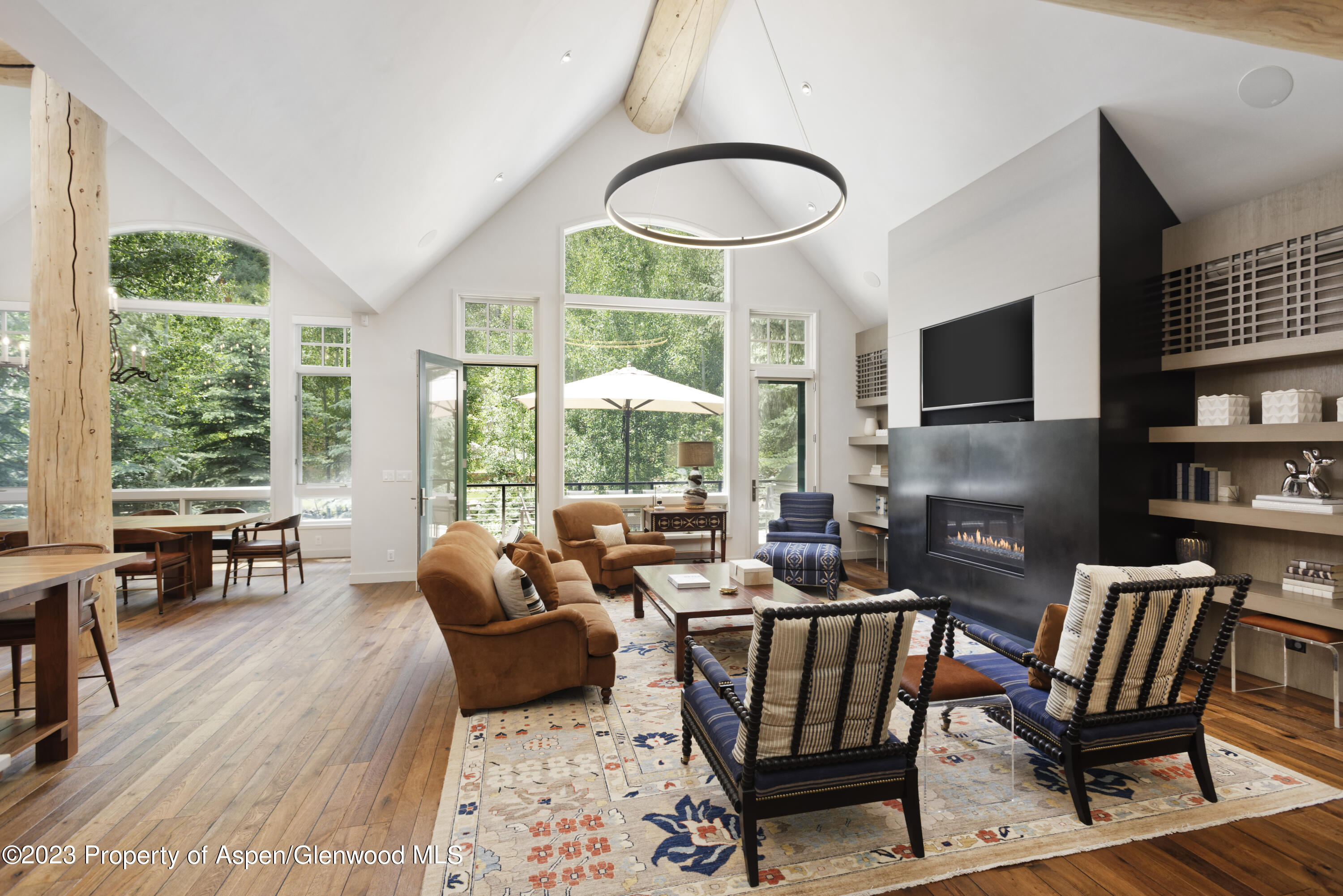 a living room with furniture fireplace and large windows