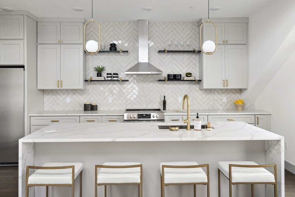 a kitchen with stainless steel appliances a table chairs in it and wooden floors