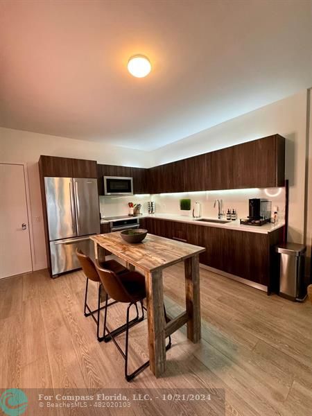 a kitchen with a table chairs refrigerator and cabinets