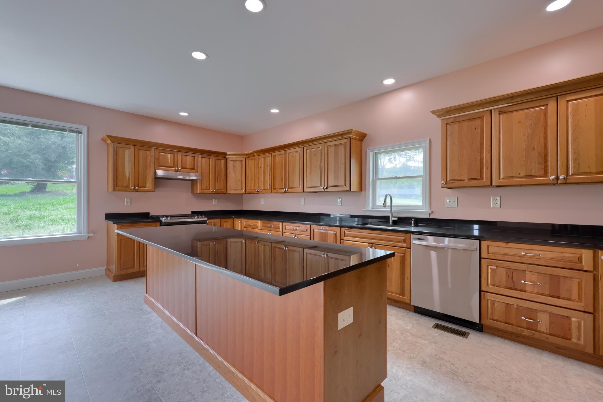 a kitchen with stainless steel appliances granite countertop a stove a sink and a refrigerator