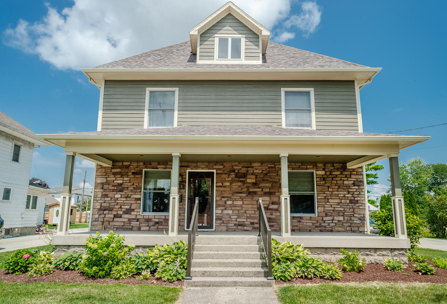 a front view of a house with garden and porch