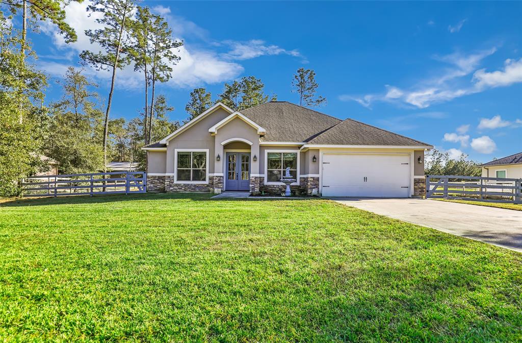 a view of a house with a big yard and large trees