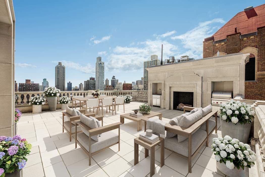 a view of a terrace with couches potted plants and a fireplace