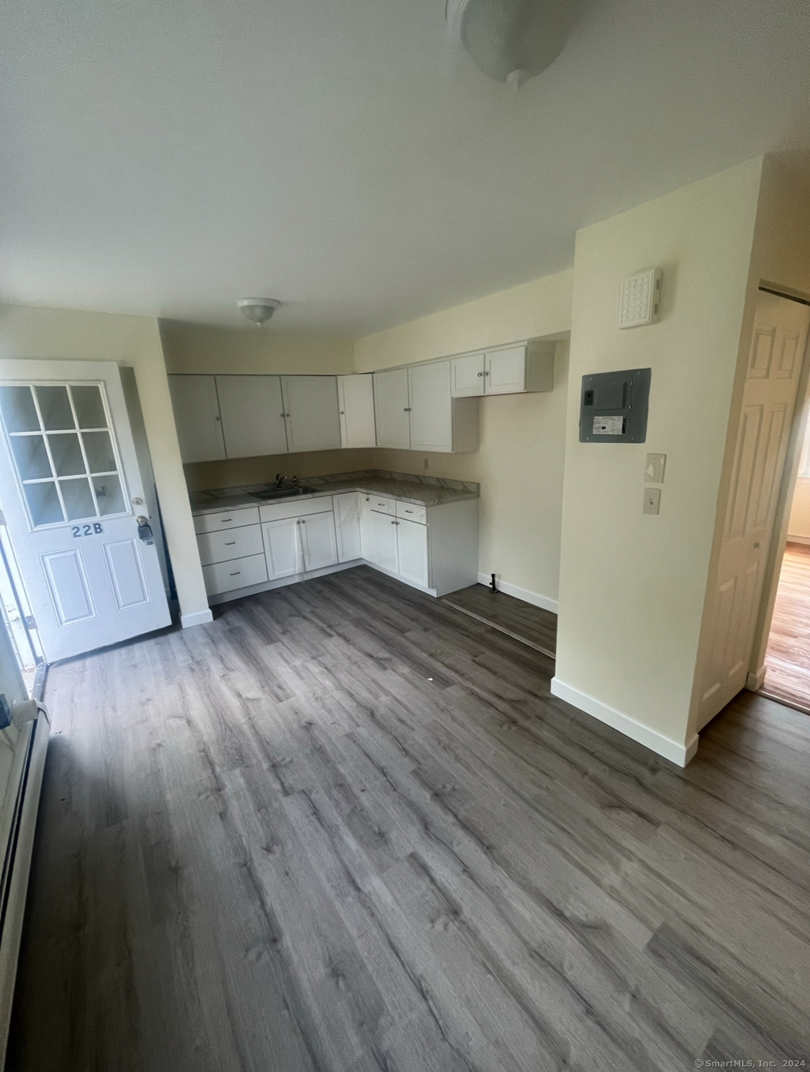 a view of a kitchen with wooden floor and electronic appliances