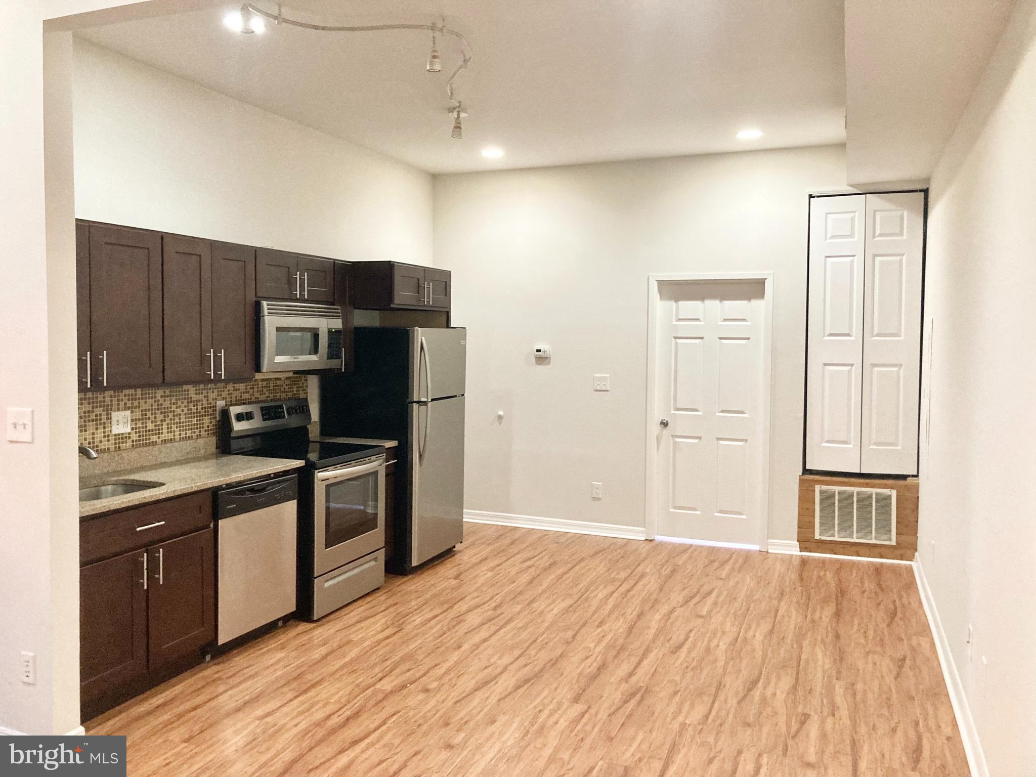 a kitchen with stainless steel appliances granite countertop a refrigerator and a stove top oven