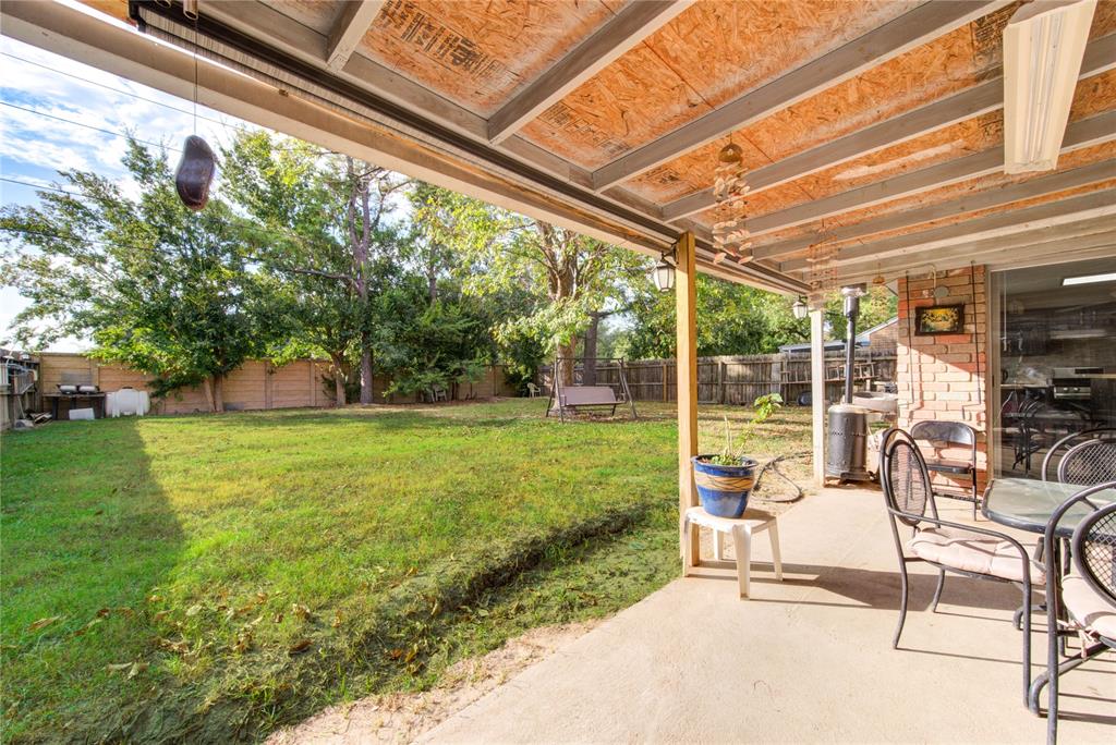 a view of a chair and table in backyard of the house