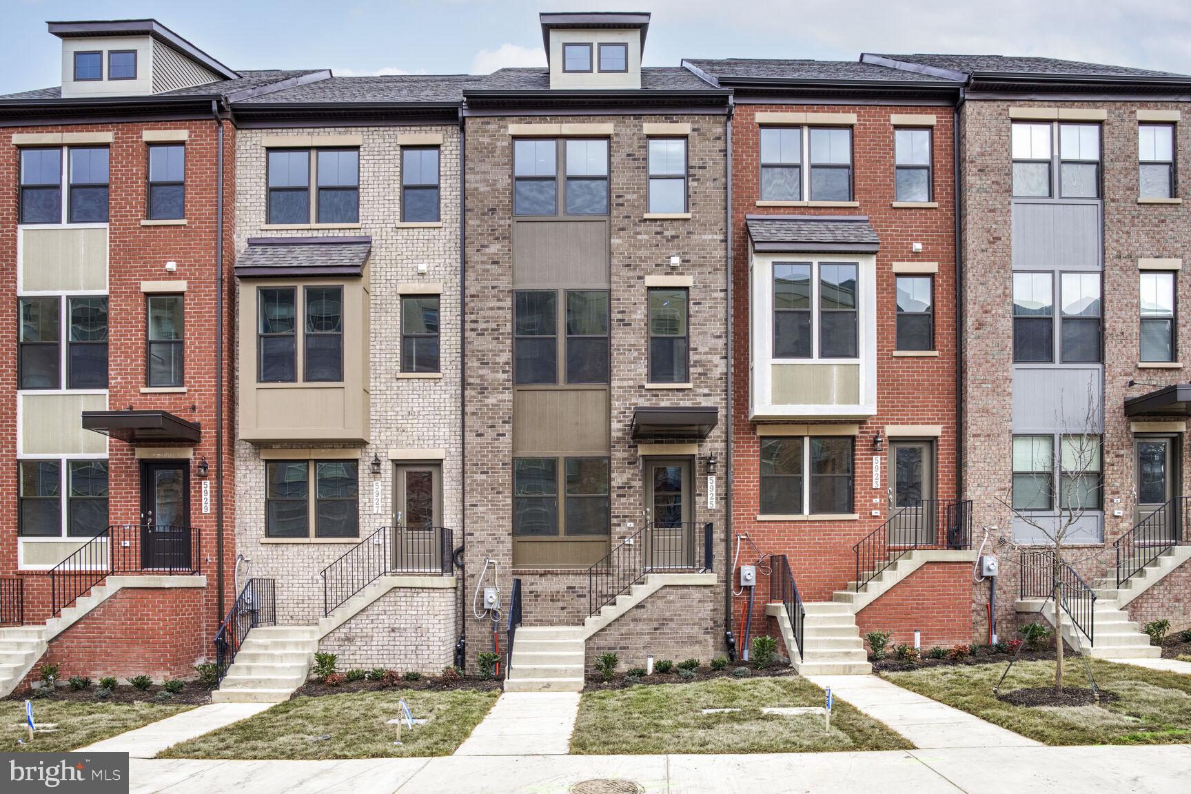 a front view of a residential apartment building with a yard