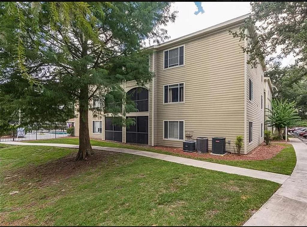 a view of a house with backyard and a tree