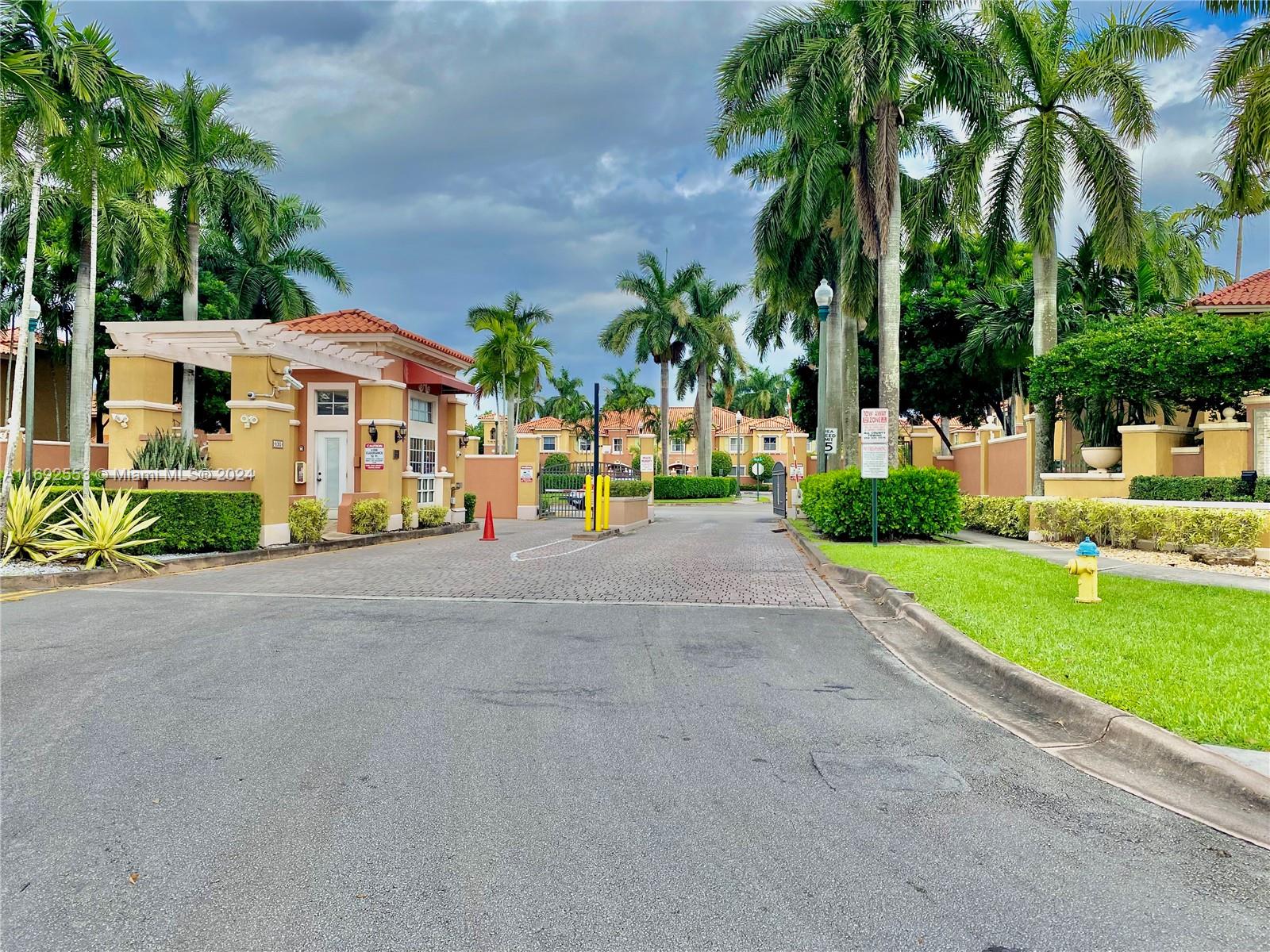 a view of a house with a yard and palm trees