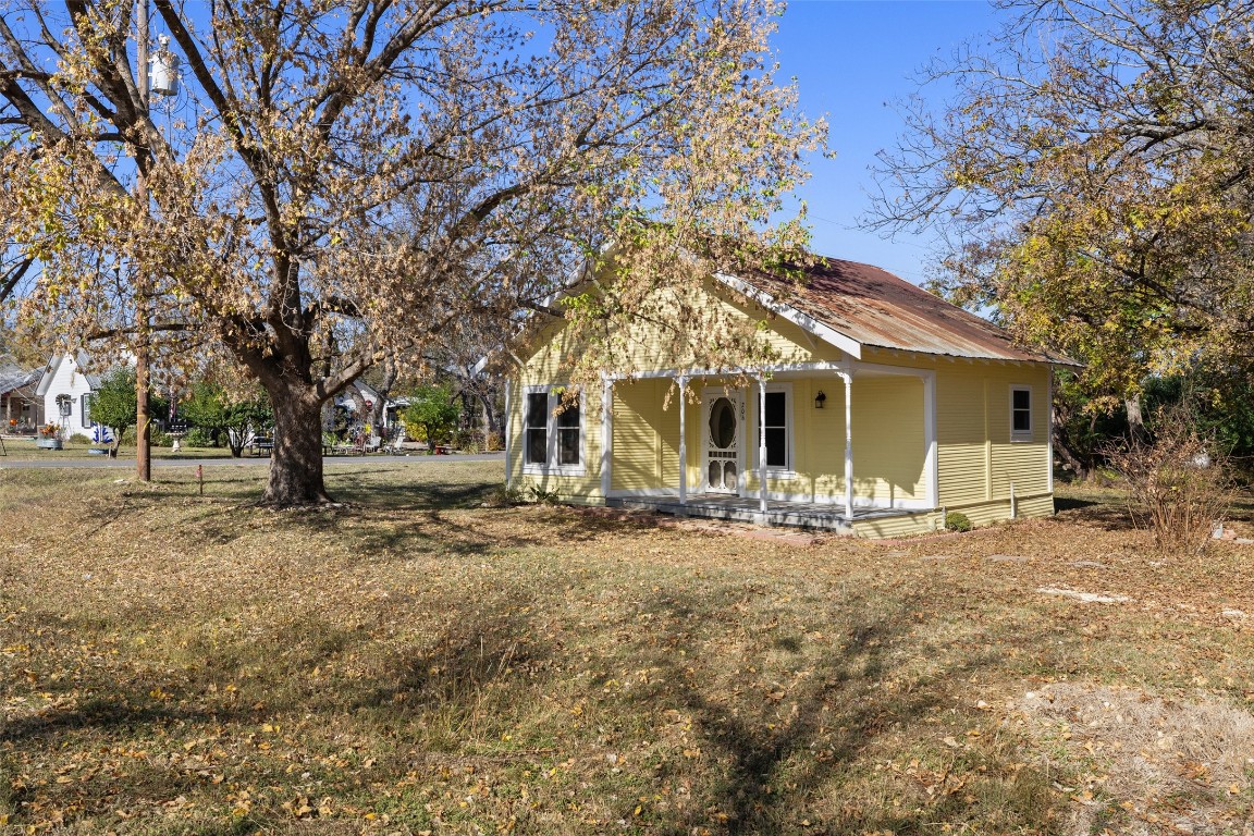 a view of a house with backyard and trees