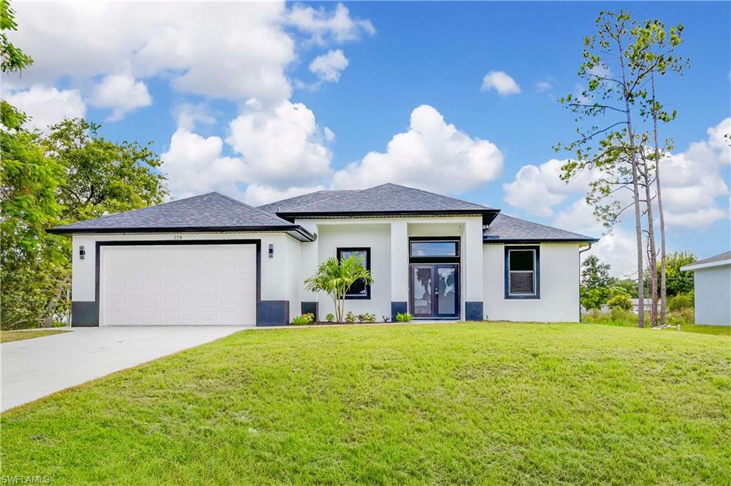 Prairie-style home with a garage, french doors, and a front lawn