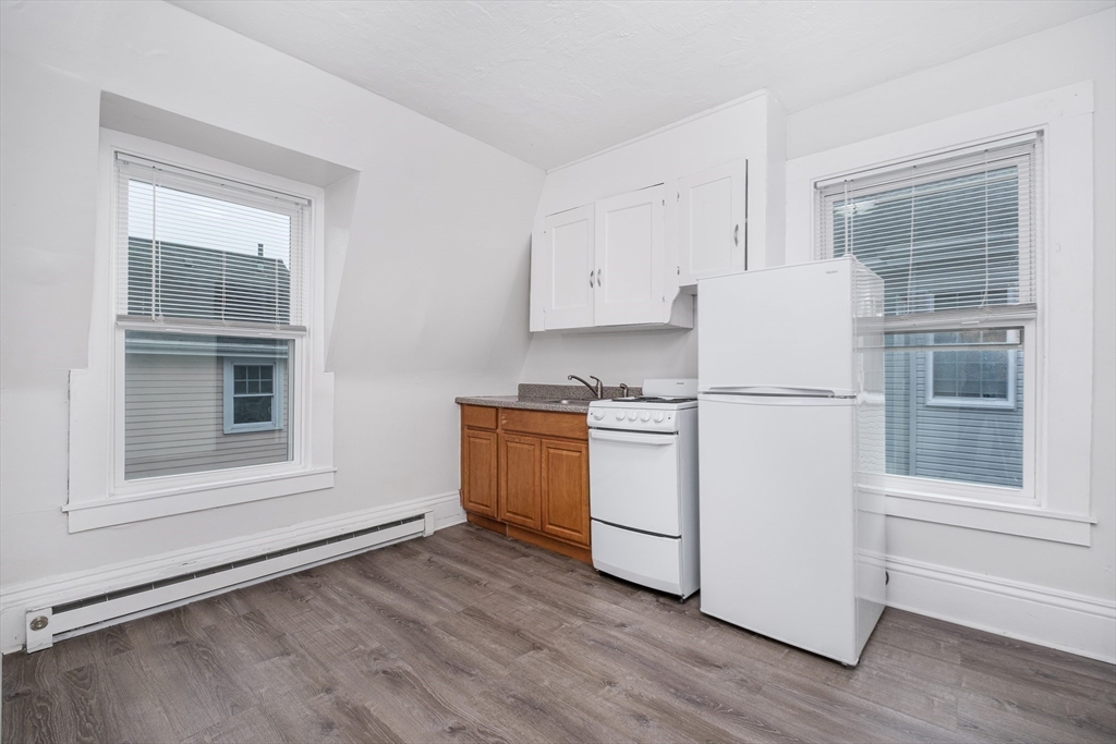 a kitchen with white cabinets and white appliances