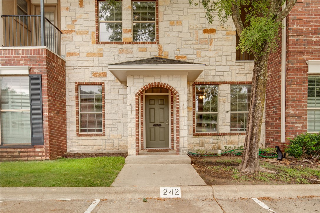 front view of a brick house with a yard