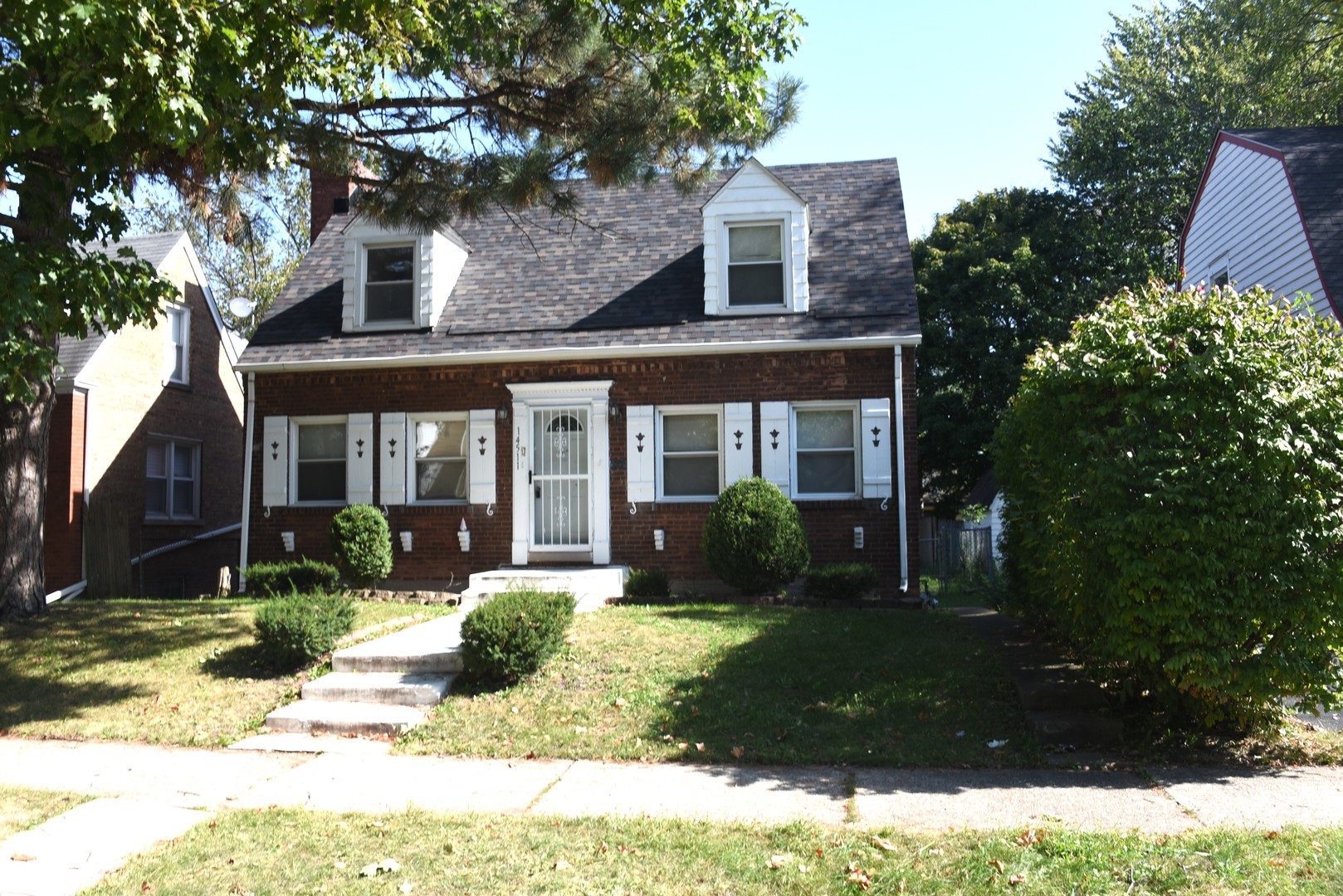 a front view of a house with a yard and potted plants