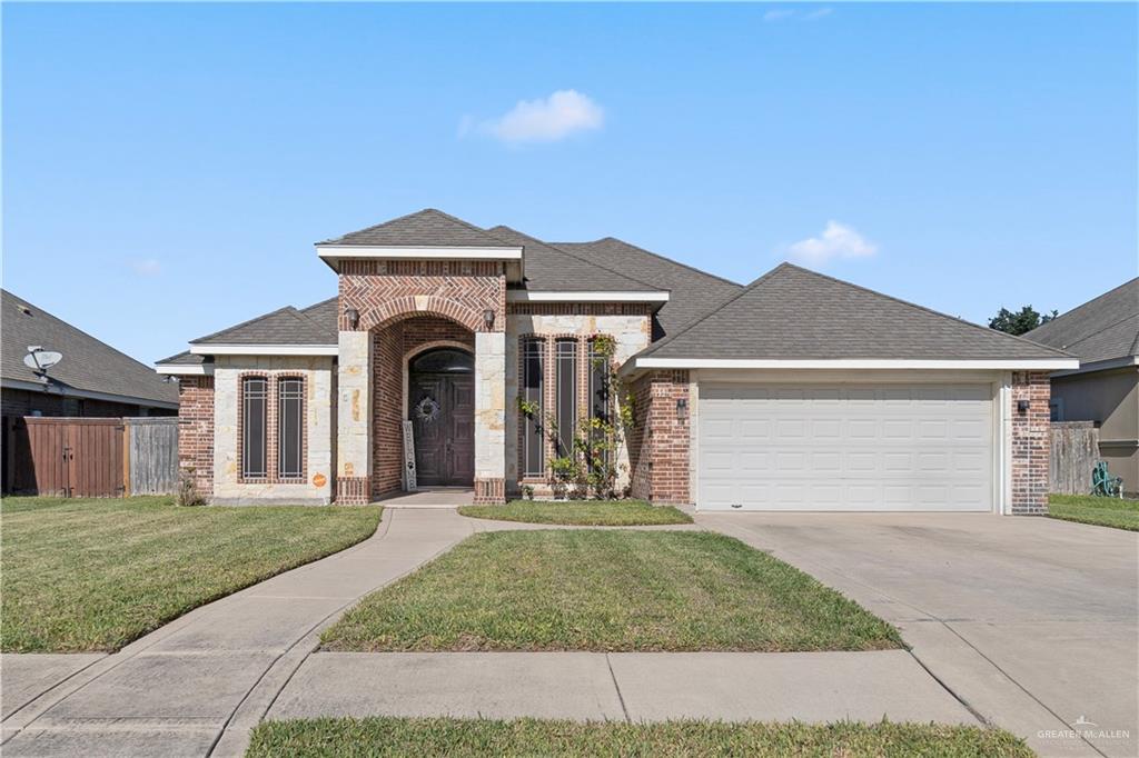 View of front of house with a front yard and a garage