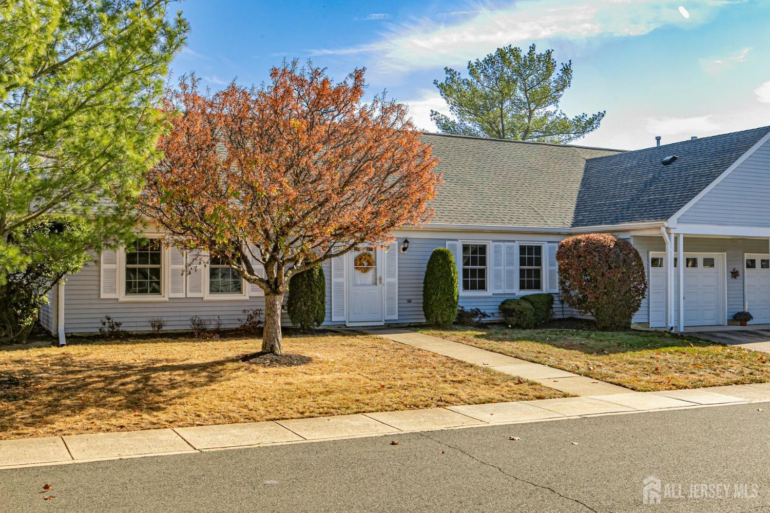 a view of a house with a tree in front of it