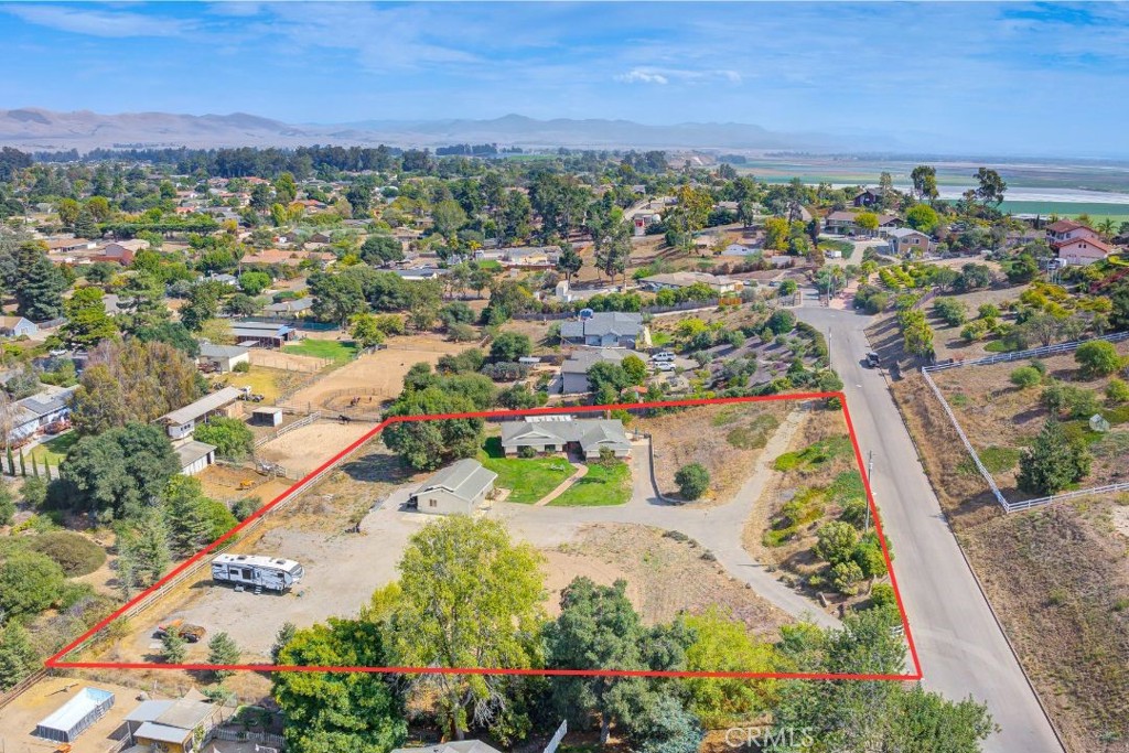 an aerial view of residential houses with outdoor space and trees