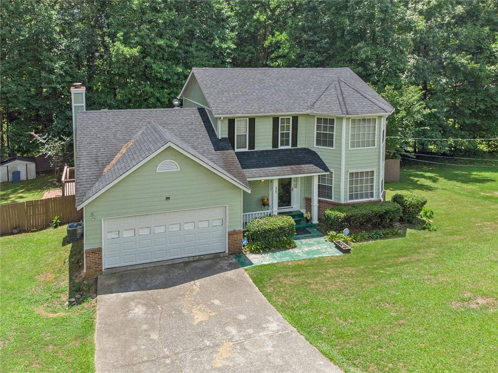 a front view of a house with a yard and trees