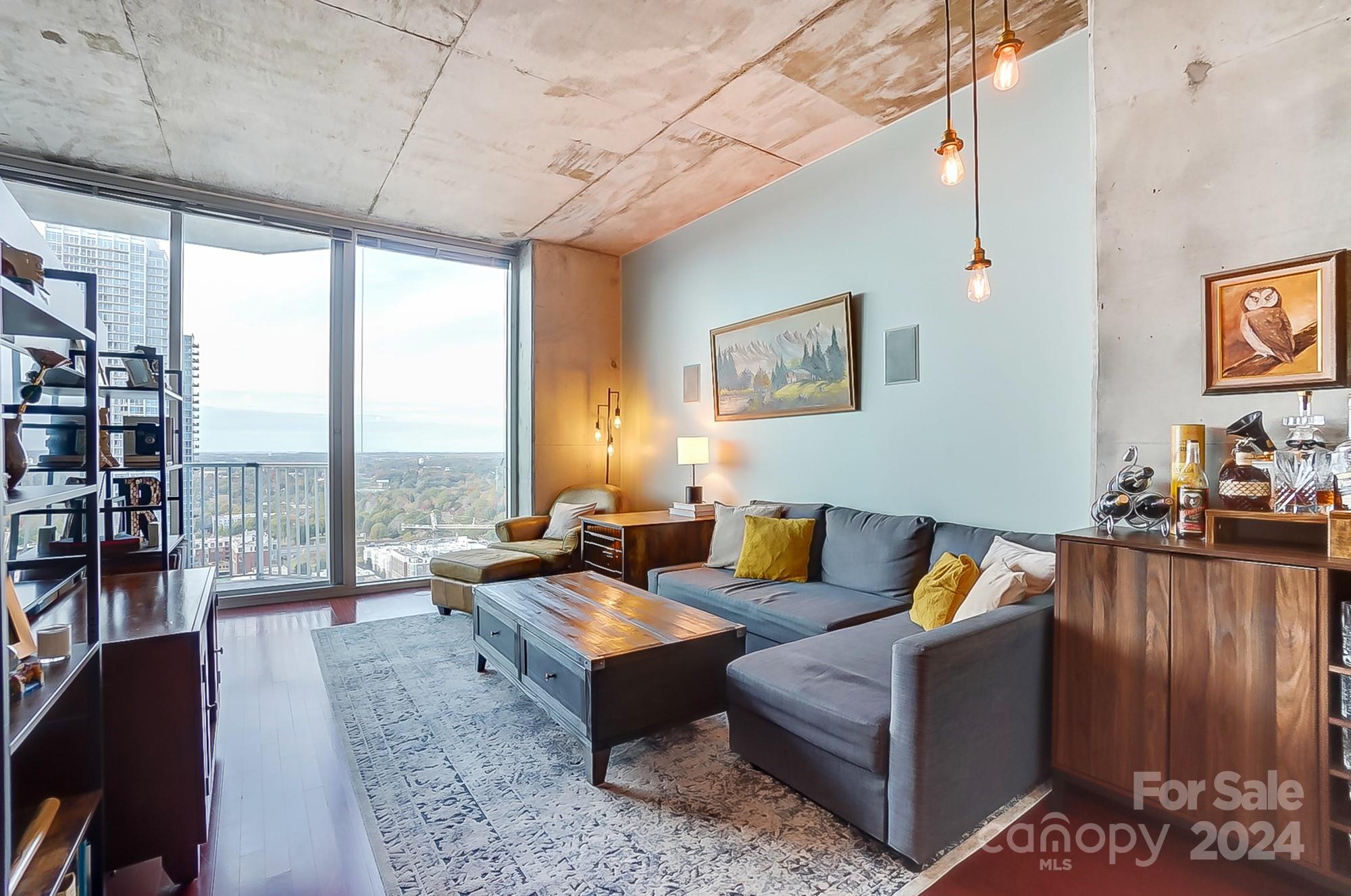 a living room with furniture and a floor to ceiling window