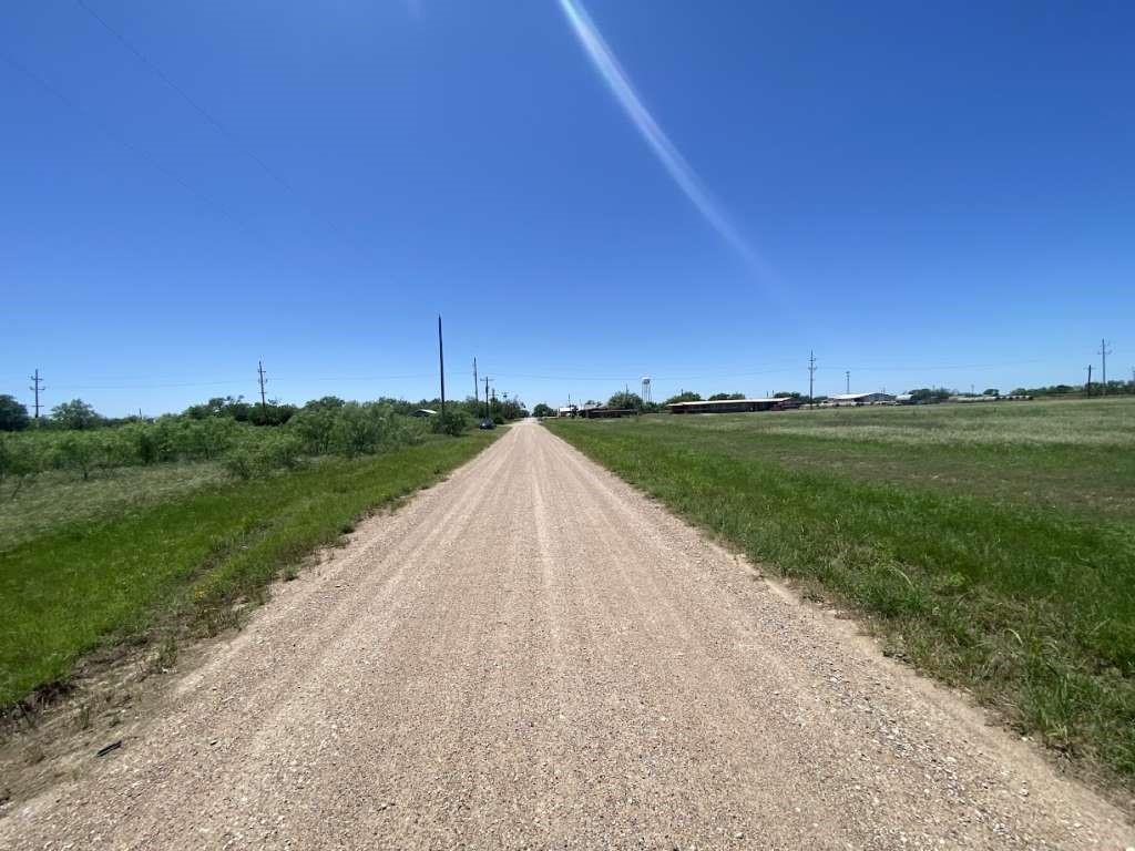 a view of a street with a house in the background