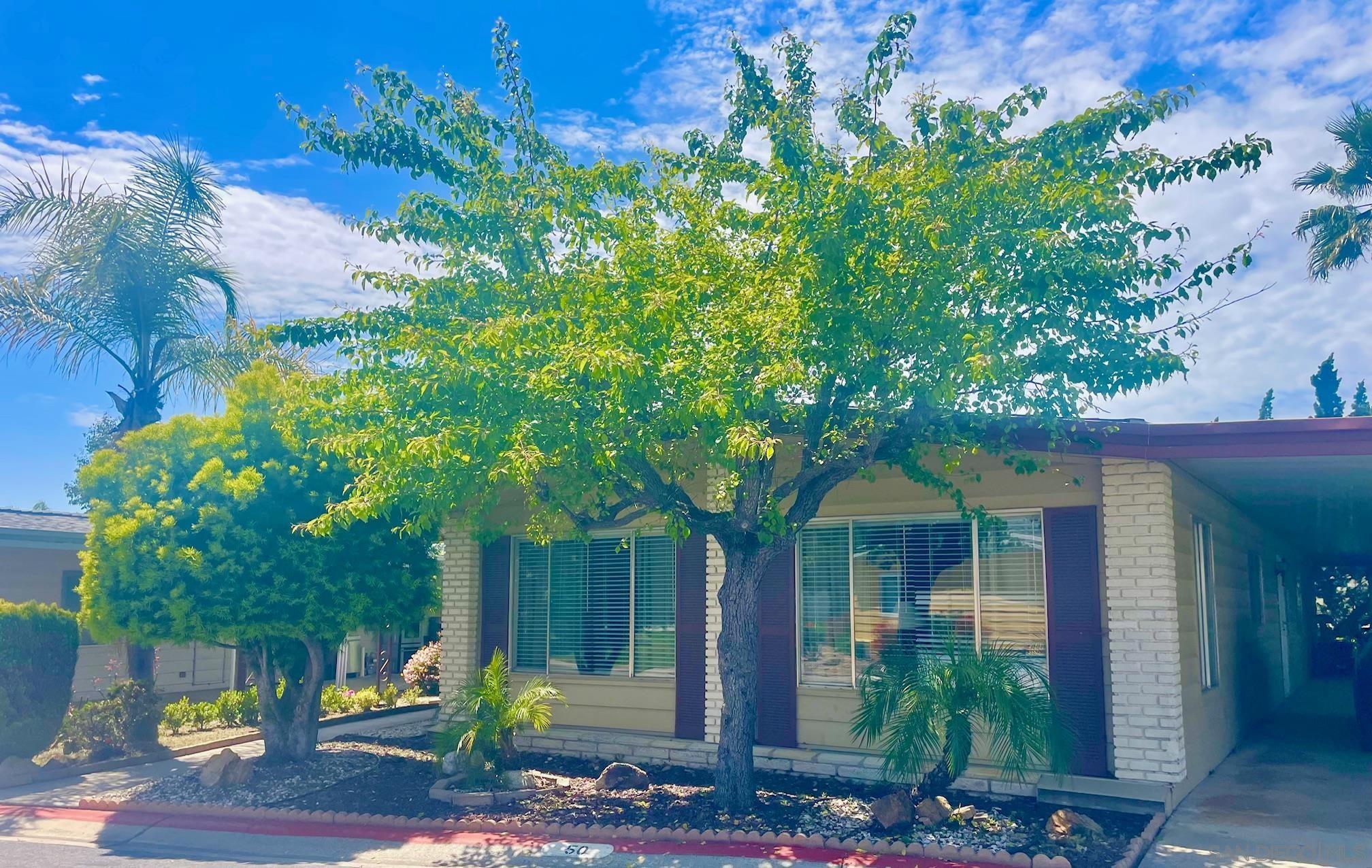 a front view of a house with a tree