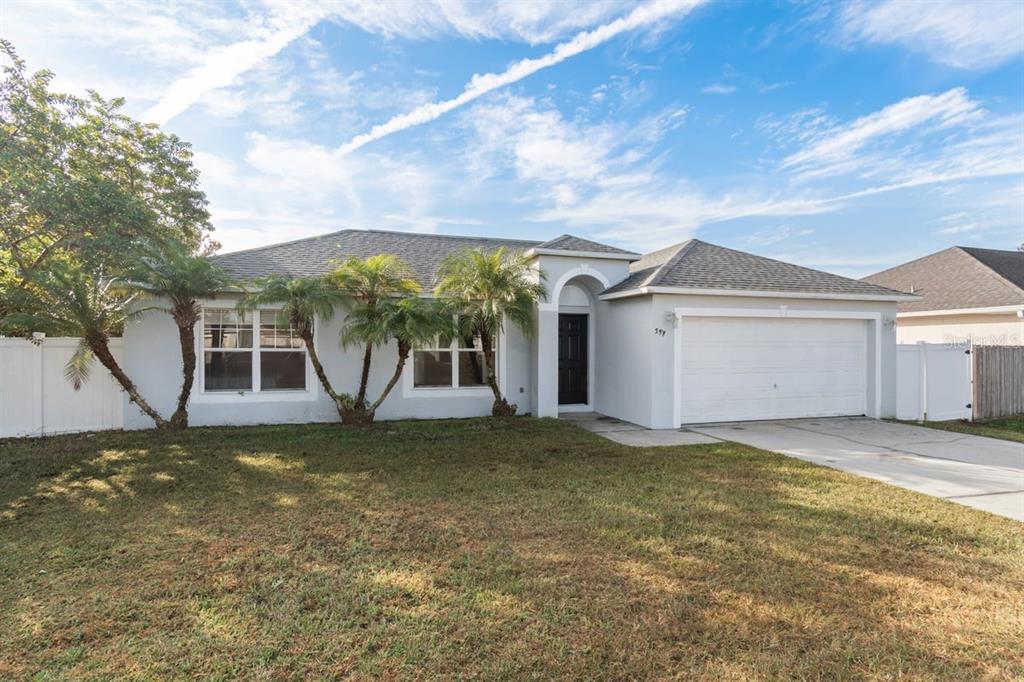 a view of a house with a yard and a garage