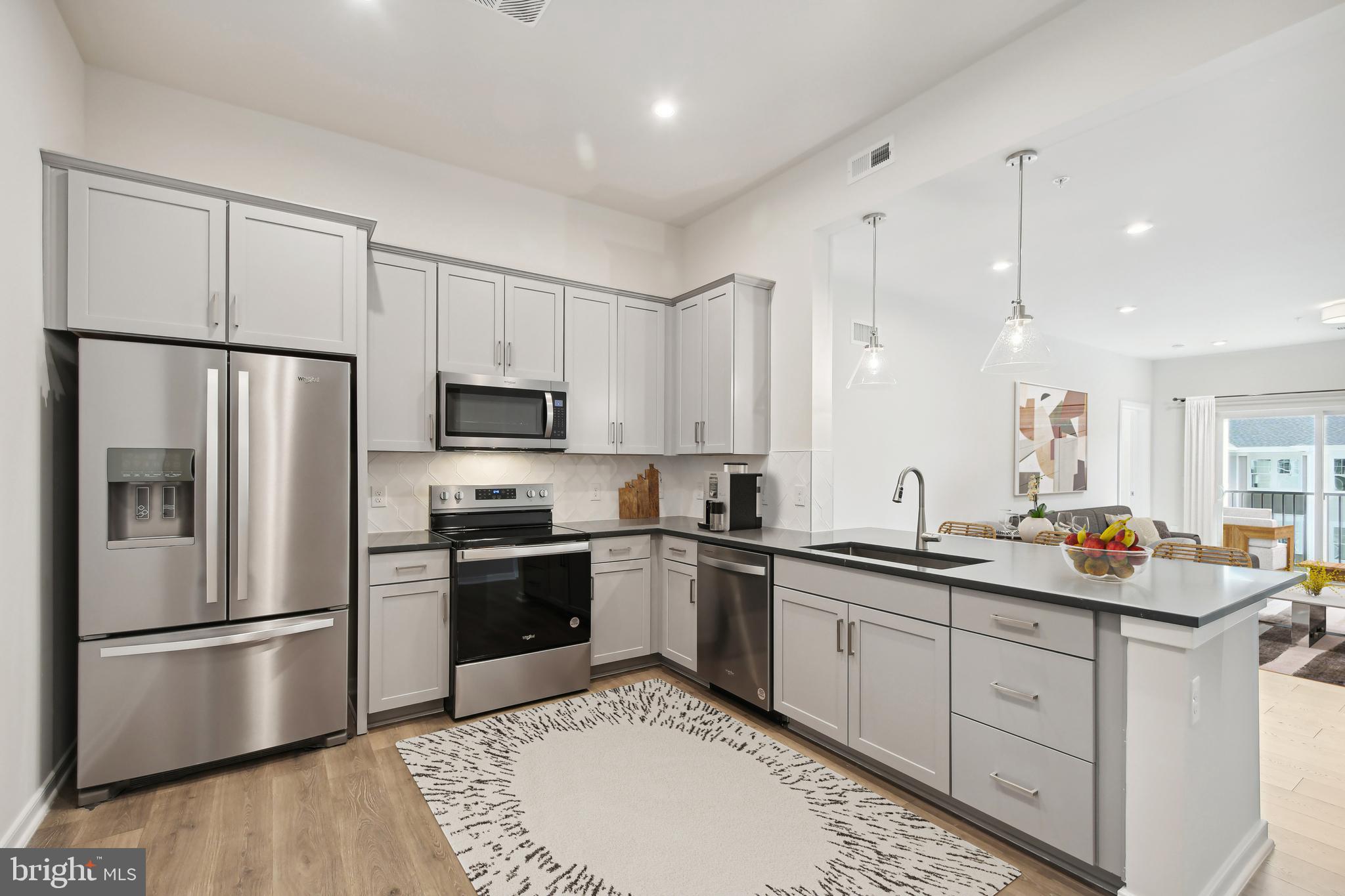 a kitchen with stainless steel appliances granite countertop a refrigerator sink and white cabinets