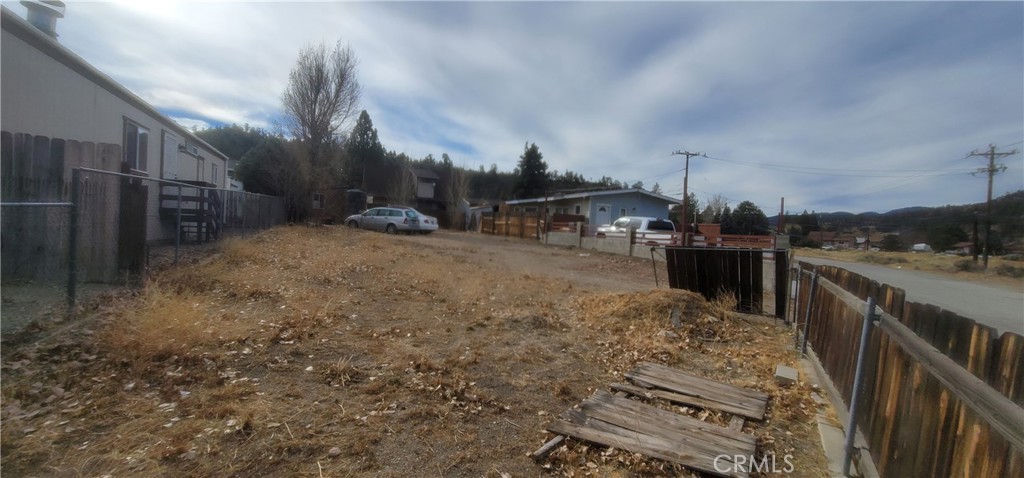 a view of a backyard with wooden fence