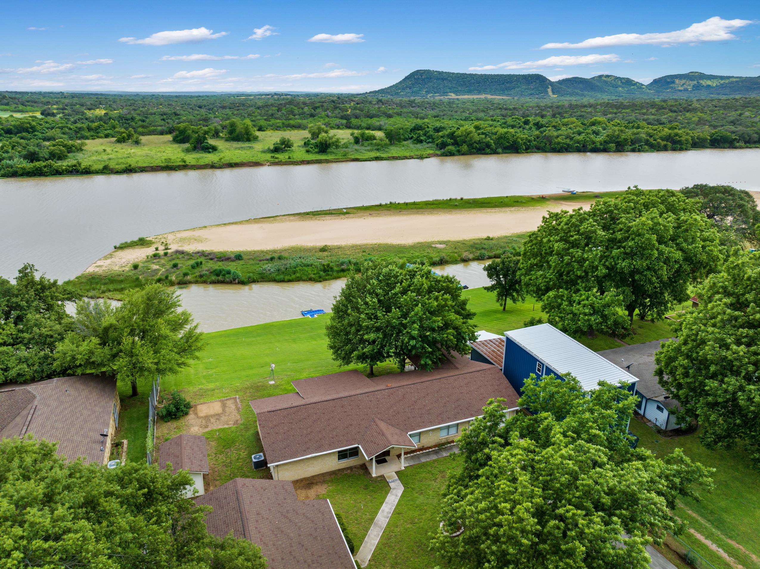 an aerial view of a house with a garden and lake view