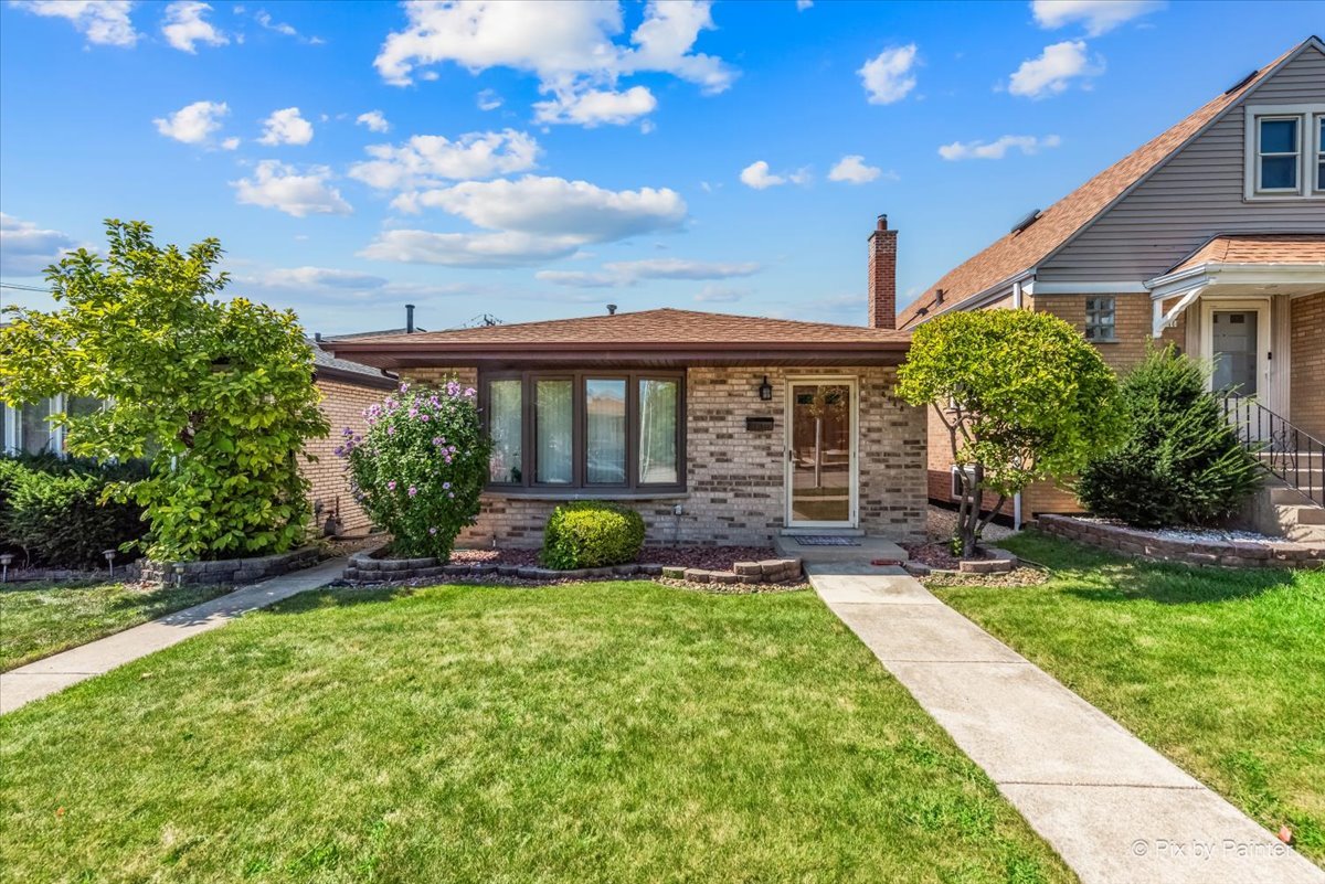 a view of a house with a yard and potted plants