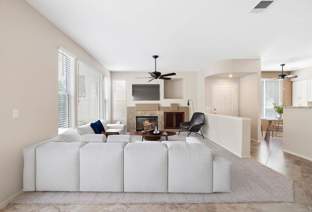 a living room with furniture a fireplace and a chandelier