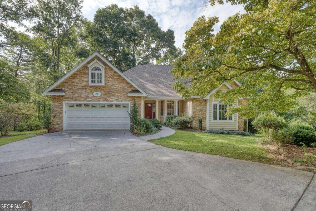 a view of a house with a yard and large tree