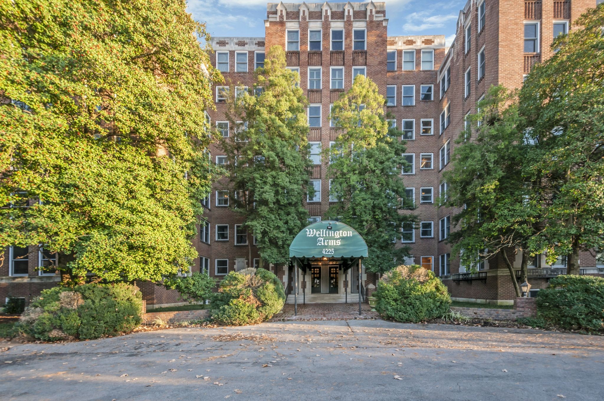 a front view of a multi story residential apartment building with a yard