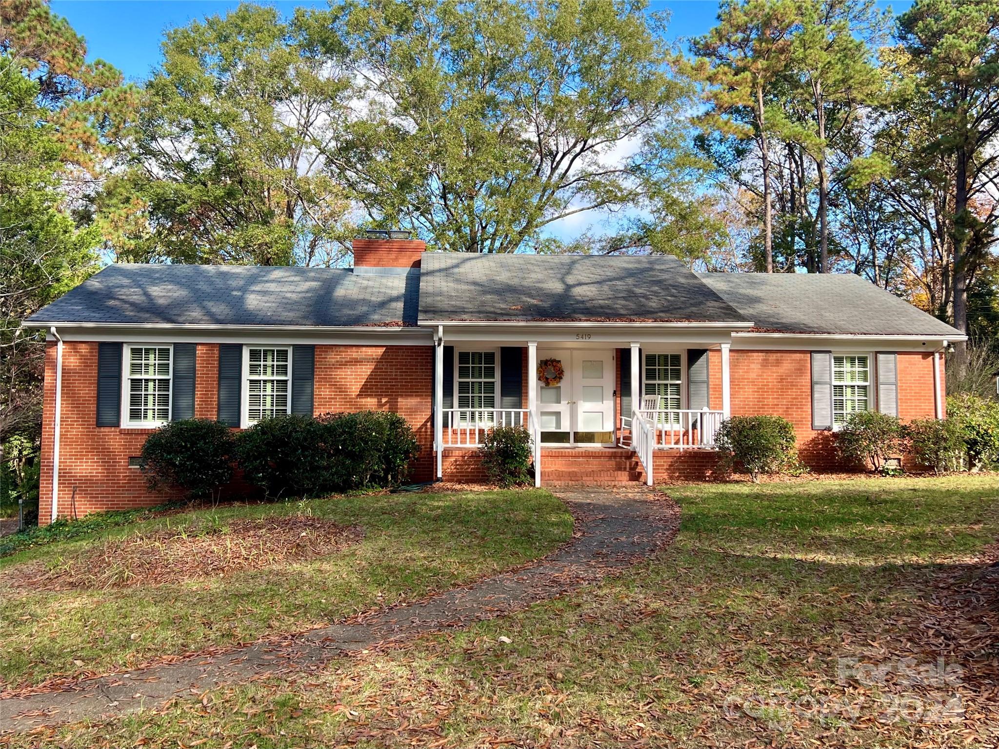 a front view of a house with a yard and trees